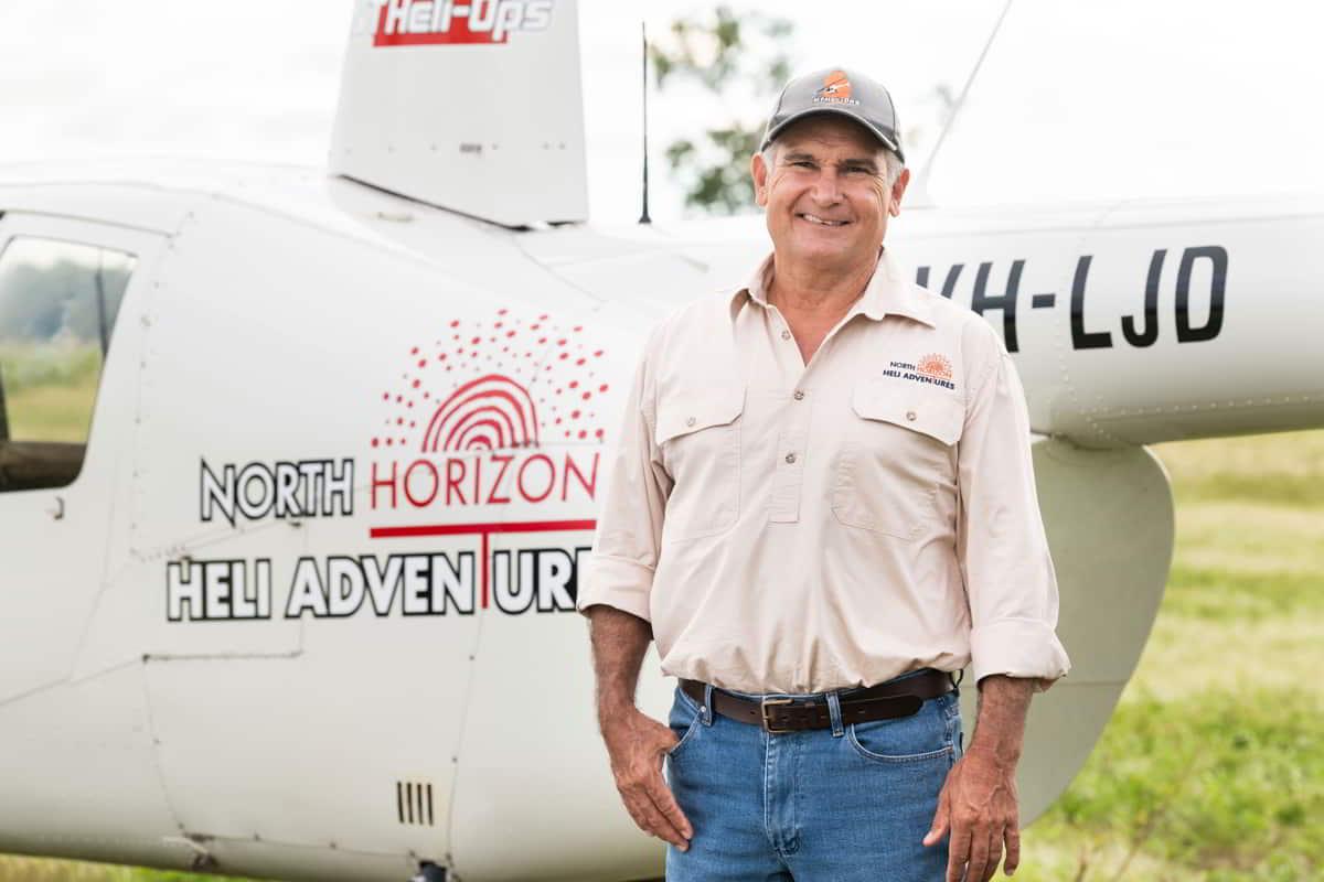 Doug McBean standing next to his helicopter for business North Horizon Heli Adventures